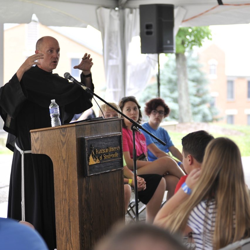 Father Dave giving talk in the tent during main campus 1, 2015