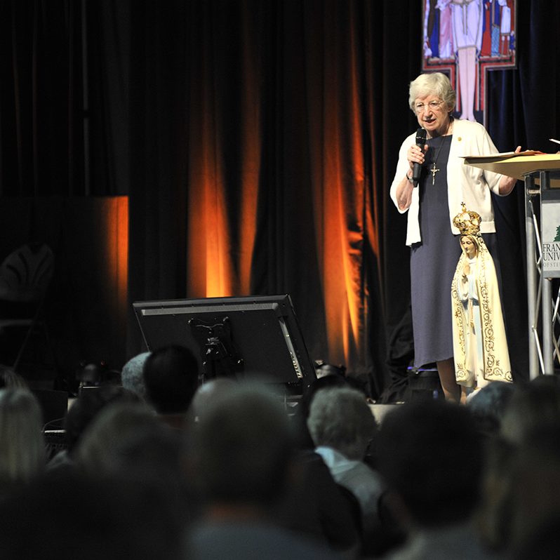 women giving talk in the fieldhouse during power and purpose conference, 2015