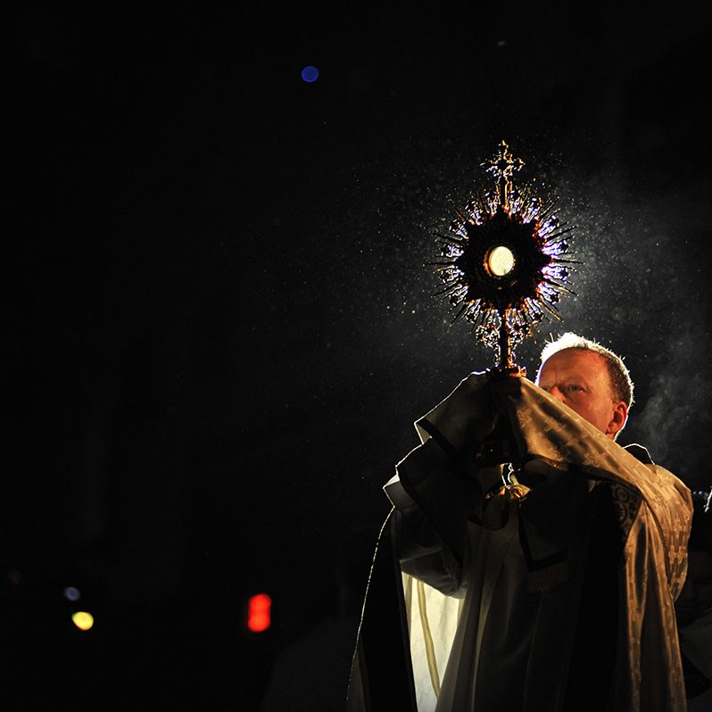 Father Dave lifting the Eucharist during adoration at conference, 2015