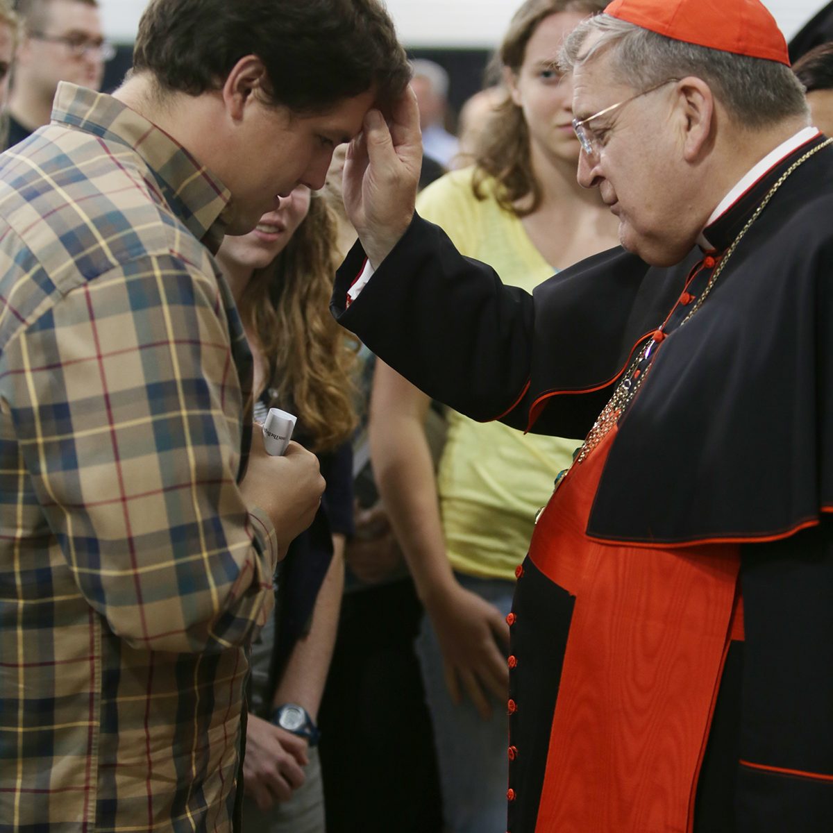 Cardinal Praying over man