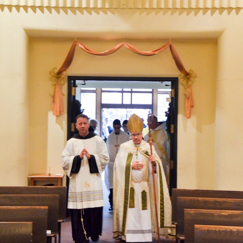 bishop montforton and Father dave walking through the holy door, in Christ the king chapel