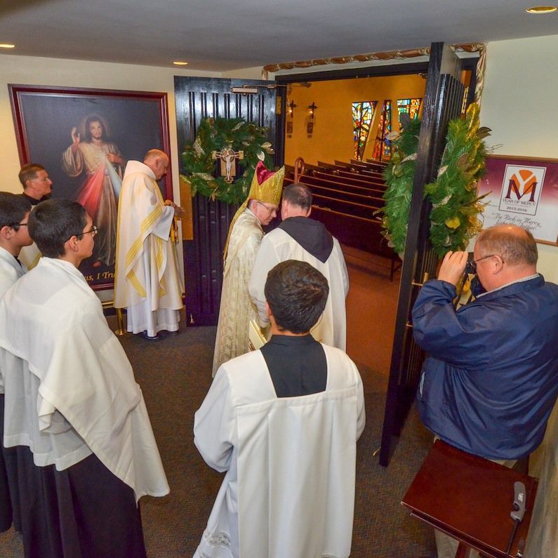 overhead of bishop montforton opening the holy door