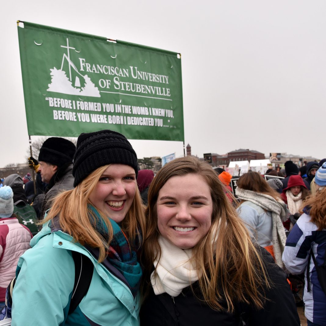 two students smile for a picture at the march for life