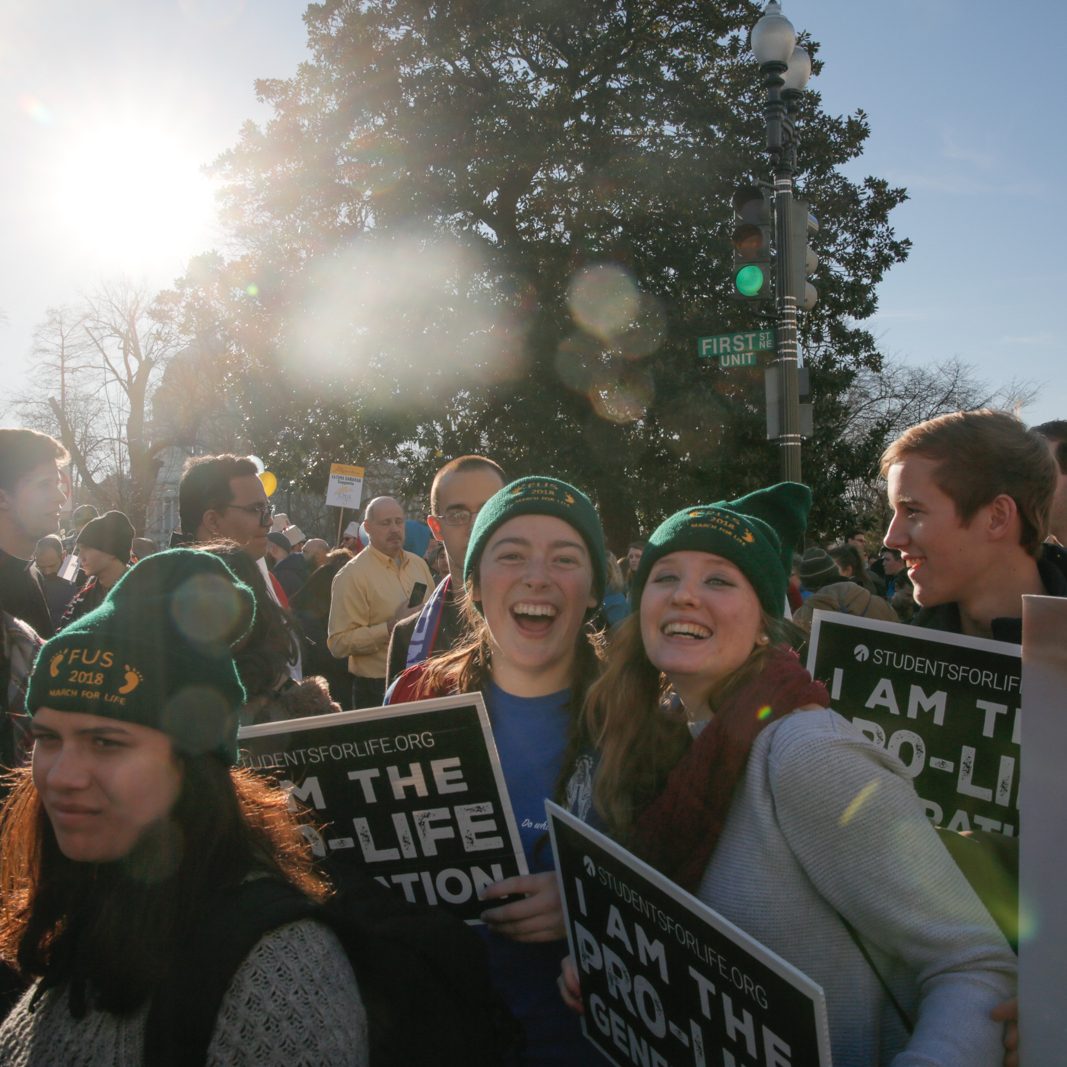 group of students march with pro-life signs at the march for life