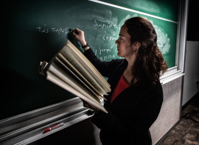 Female Professor writing on chalkboard