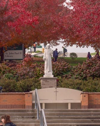 St. Francis Statue and red leaves on trees