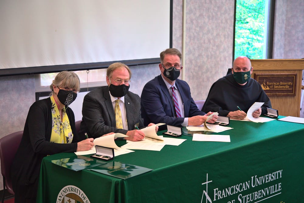 Dr. Jill Loveless, WVNCC provost; Dr. Daniel Kempton, FUS vice president for Academic Affairs; Dr. Daniel Mosser, WVNCC president; and Fr. Dave Pivonka, TOR, FUS president, sign articulation agreements between the two schools.
