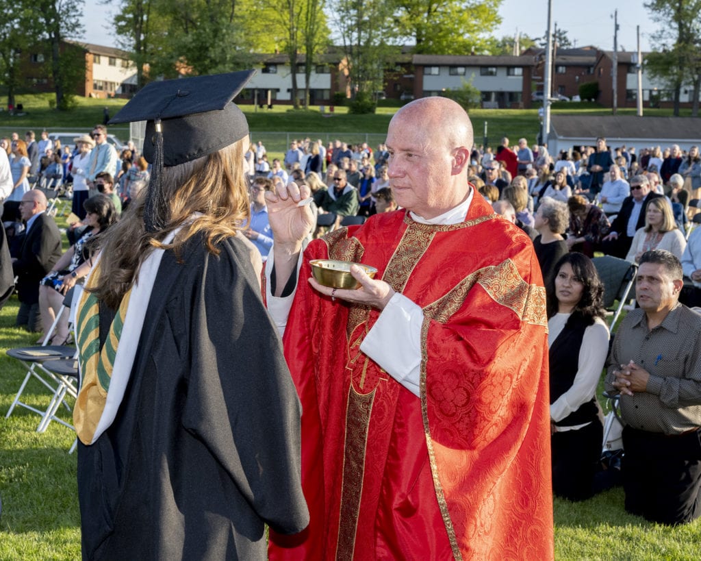 Father Dave Pivonka, TOR, distributes communion at the Baccalaureate Mass.