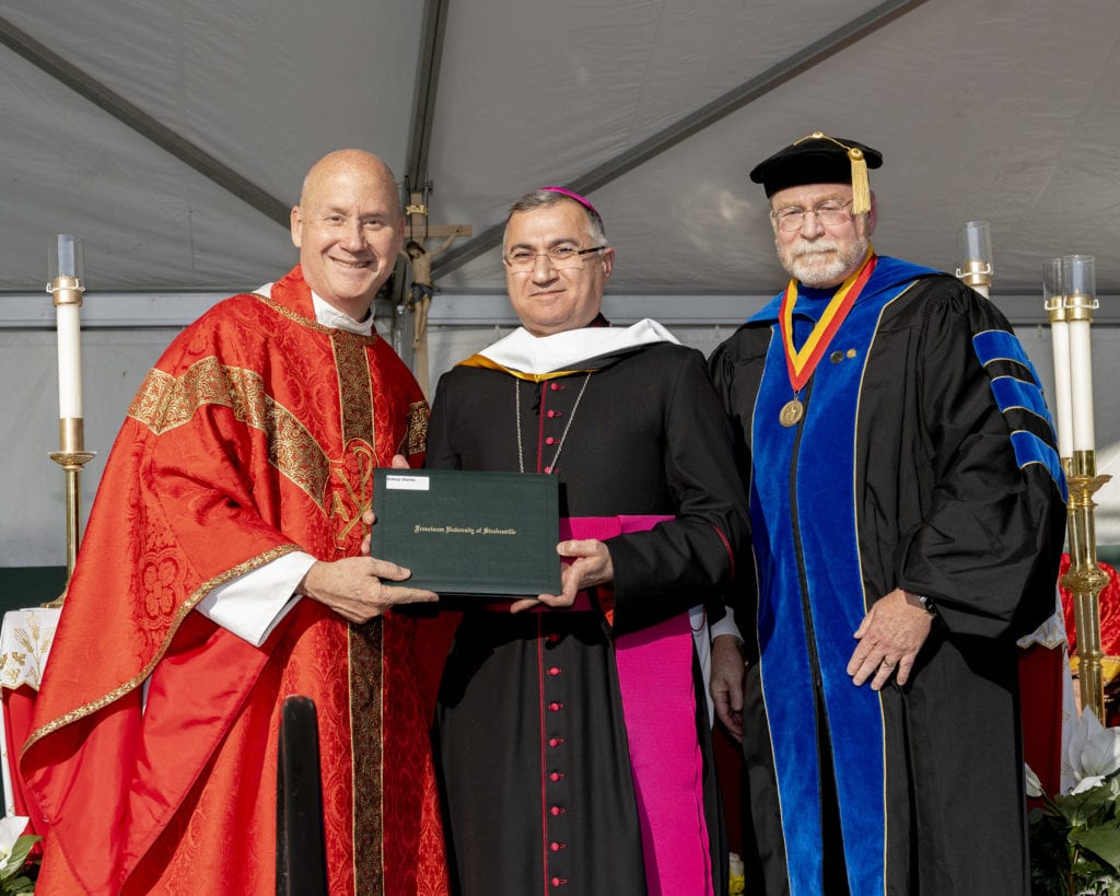 Father Dave Pivonka, TOR, president of Franciscan University (left), and Dr. Daniel Kempton, Franciscan University vice president for Academic Affairs (right), present Archbishop Bashar Matti Warda, CCsR, with his honorary doctorate of humane letters.