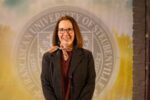 Dr. Monica Anderson standing in front of a university seal.