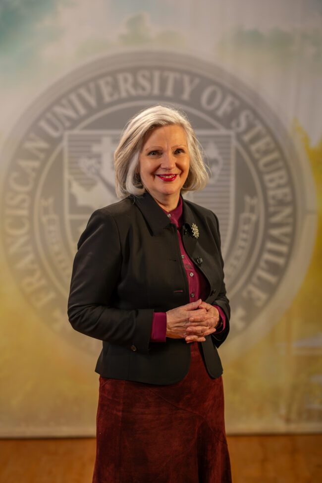 To Web – Jacqueline Leonard FEB2025 –2 Dr. Jacqueline Leonard standing in front of a university seal.
