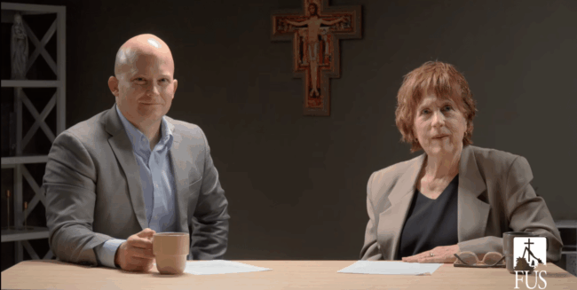 Dr. John Bishop and Dr. Deborah Savage seated at a table for an interview.