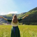A girl stands in a field in Austria