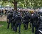 armored police standing in front of crowd