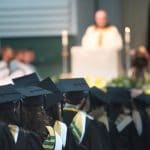 back of graduating students in fieldhouse