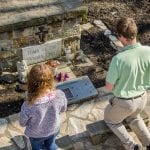 two students kneeling before the tomb of the unborn child