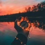 Hand Holding Christmas lights and compass