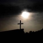 Cross with clouds and the sun