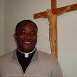 Priest in front of Crucifix