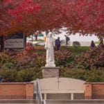 St. Francis Statue and red leaves on trees