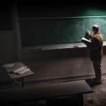 Professor writing on a chalkboard