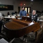 professor playing piano for students