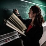 Female Professor writing on chalkboard
